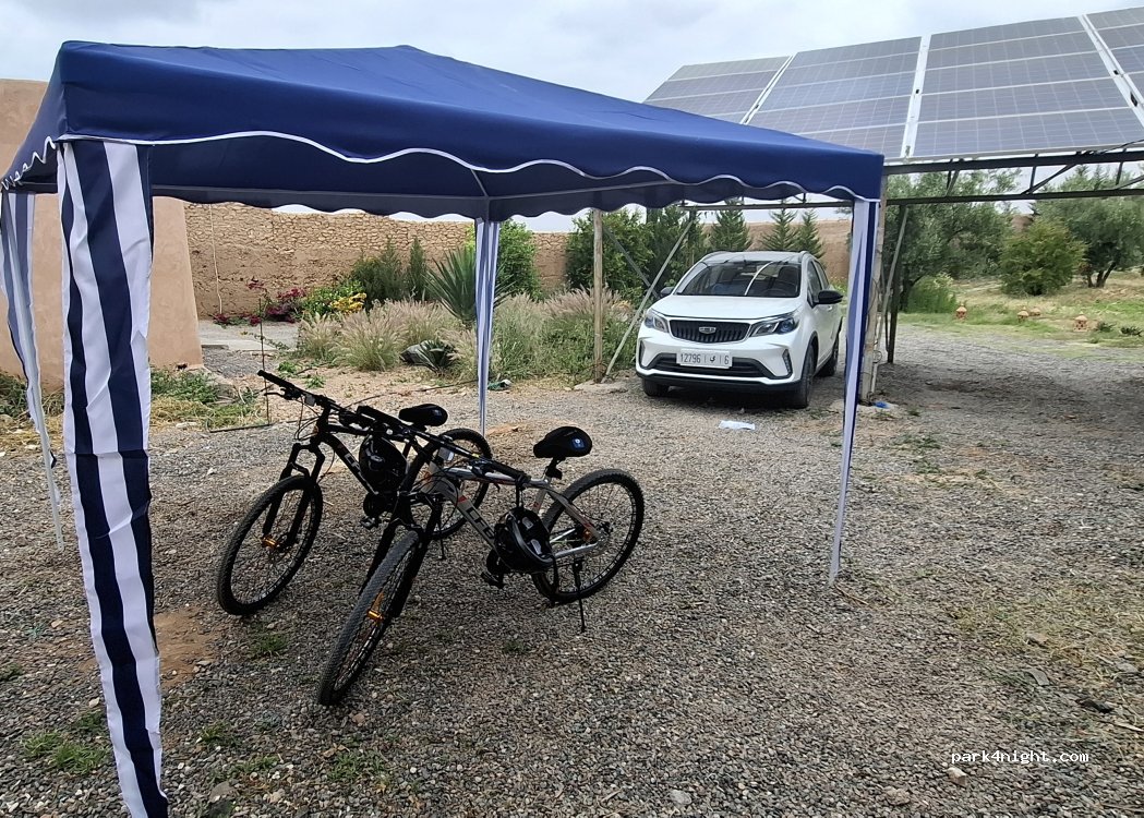 Espace de stationnement ombragé avec tonnelle et vélos