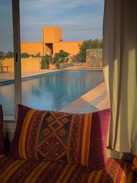 Salon marocain avec coussins traditionnels et vue sur la piscine