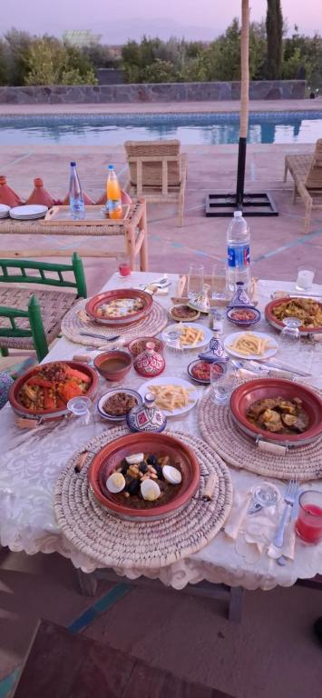 Dîner marocain servi au bord de la piscine, avec tajines et salades