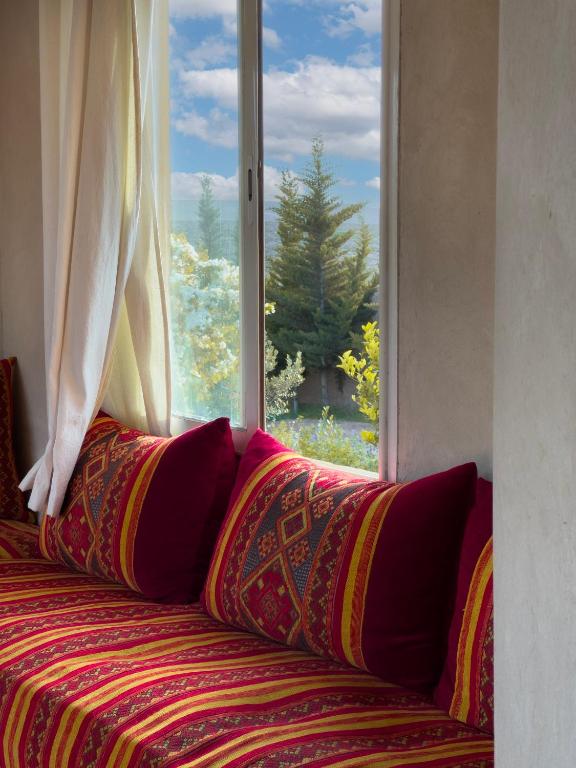 Salon marocain intérieur avec banquettes et coussins rouges traditionnels
