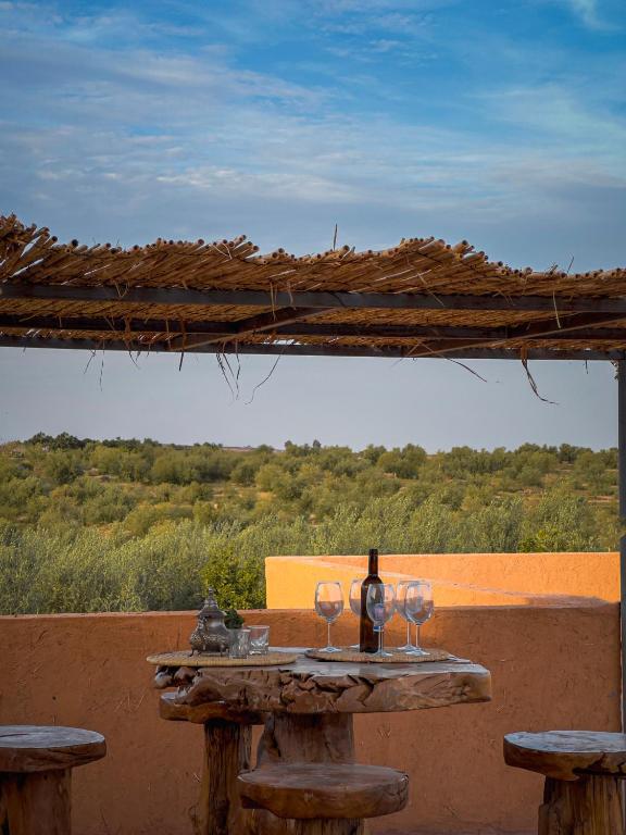 Terrasse couverte avec table en bois surplombant les oliviers