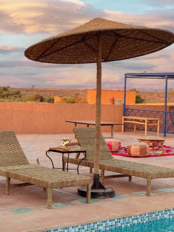 Transats et parasol en paille au bord de la piscine